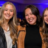 Three grads smile for a group photo